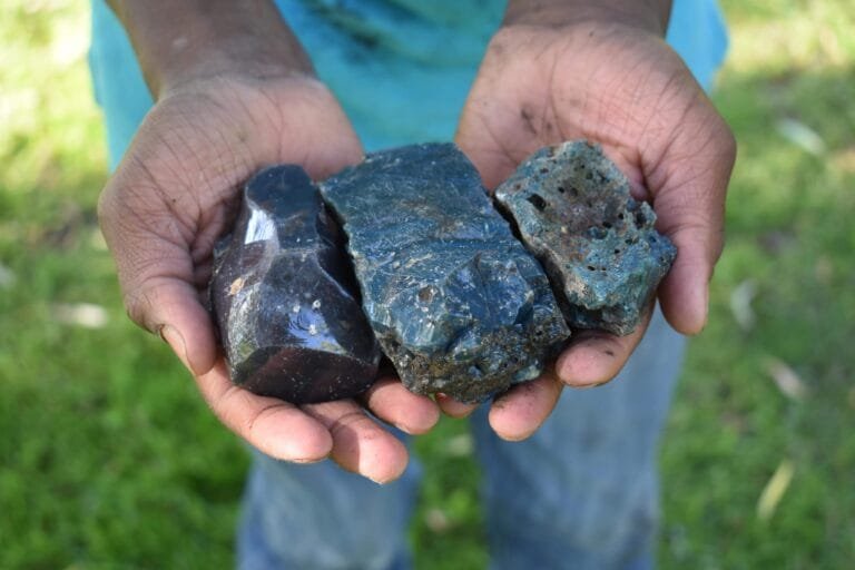 close-up-man-hands-holding-rock-land